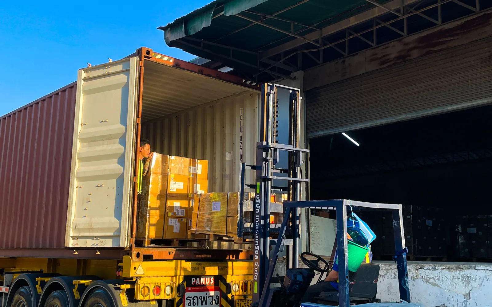 Industrial warehouse with forklift loading shipping containers